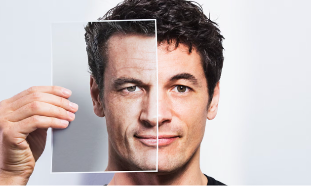 Image of a man holding up an image of an aged version of himself